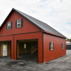 Two-story two-car garage with peak roof and red siding with dark trim